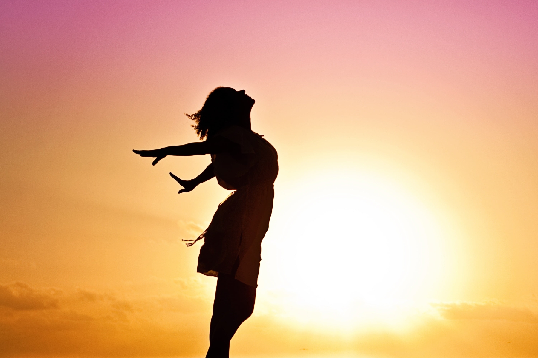 Euphoric Sunrise: A Woman's Silhouette in a Dress on a Beach
