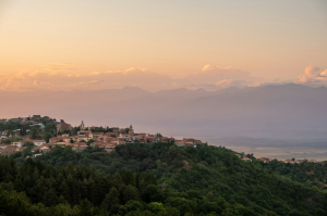 Golden Summer Sunset Over Sighnaghi: A Scenic View of Georgia's Hillside Village Under an Orange Sky