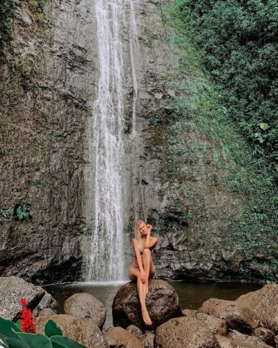 Nature's Fashion Runway: A Model Amidst Waterfall Scenery