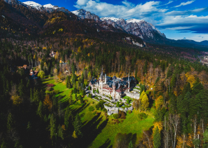 Peles Castle: A Majestic Jewel Amidst Autumn's Vibrant Colors and Snow-Capped Mountains