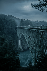 The Majestic Gray Metal Bridge Spanning Across a Tranquil River