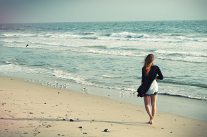 Tranquil Stroll: A Woman's Peaceful Walk on the Venice Beach Sand